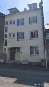 a white building on the side of a street at Logement refait à neuf - Résidence - Chez Christian in La Bourboule