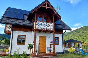 une maison avec des panneaux solaires sur le toit dans l'établissement Gazdówka - najlepsza miejscówka domek w Pieninach, à Krościenko nad Dunajcem