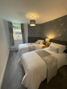 a hotel room with two beds and a window at The Gatehouse is in a 18th century estate, BHX,NEC in Over Whitacre
