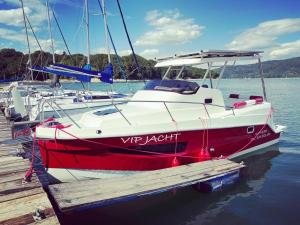 a red and white boat parked at a dock at VIP JACHT in Polańczyk
