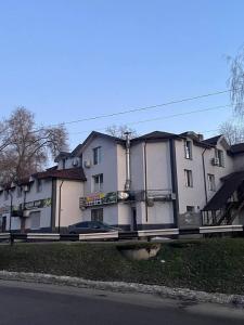 a large white building on the side of a street at PitStop Motel in Kamianske