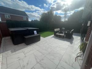 a patio with a grill and a table and chairs at Luxury 4 bedroom Retreat; with hot tub & parking in Birmingham