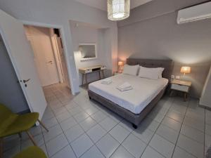 a bedroom with a bed and two tables and two lamps at Urban City Apartments in Xylokastro