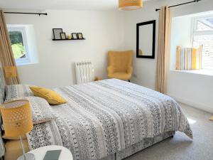 a bedroom with a bed and a chair at Your luxurious and secluded retreat in Cornwall in Helston