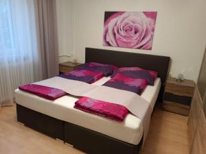 a bedroom with a bed with pink and purple pillows at Modern Apartment in Arnoldstein with Garden in Arnoldstein