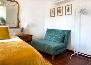 a bedroom with a green chair next to a bed at Los Cuatro Cantones - Con BARBACOA in Ariza