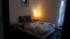 a bedroom with a bed with a lamp on it at LOFT 100m2 in Toulon