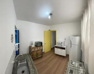 a kitchen with a sink and a refrigerator at Jardins Village Hostel - Jardim Paulista in Sao Paulo