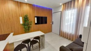 a living room with a table and chairs and a tv at Seven Seas Apartments in Nazaré