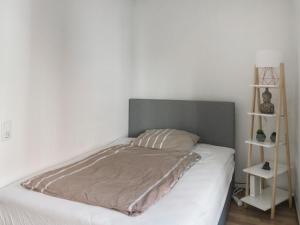 1 dormitorio con 1 cama con cabecero gris en Helles Studio in Innenstadt mit Netflix, en Mannheim