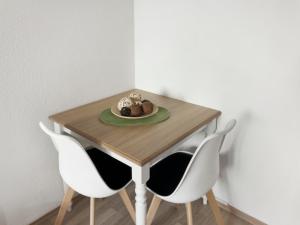 a table with two chairs and a plate of food on it at Helles Studio in Innenstadt mit Netflix in Mannheim
