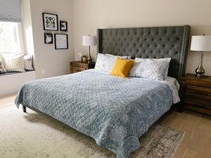 una camera da letto con un letto con una coperta blu e cuscini gialli di Inn On King Bed & Breakfast a Niagara on the Lake