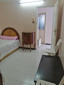 a bedroom with a bed and a table and a chair at شقة الولاء Loyalty apartment in Dumyāţ al Jadīdah