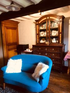 a blue couch in a living room with a cabinet at Mante et Nana in Durbuy