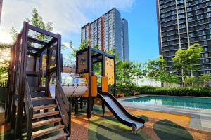 een speeltuin met een glijbaan naast een zwembad bij Cozy Klang Homestay 2-7pax 3Bedroom Netflix WIFI Infinity Pool in Klang