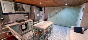 a small kitchen with a table and a stove top oven at L'Ancorotto Azzurro in Gaeta