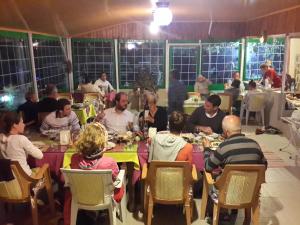 a group of people sitting at tables eating food at Rose Hotel B&B in Patara