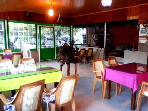 a dining room with tables and chairs and windows at Rose Hotel B&B in Patara