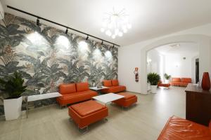 a waiting room with orange chairs and a mural at Hotel Martello in Lampedusa