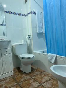 Un baño blanco con inodoro y lavabo. en Peñasalve, en Villamoñico