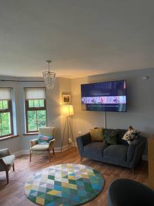 ニューカッスルにあるCheerful 4-Bed Townhouse in centre of Newcastleのソファと薄型テレビのあるリビングルーム