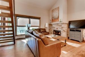 sala de estar con sofá de cuero y chimenea en Lionshead Village 1 Bedroom Condo at the Eagle Bahn Gondola en Vail