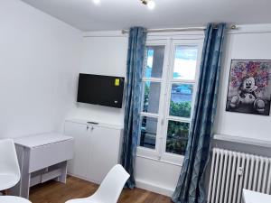 Kleines Zimmer mit einem Schreibtisch und einem Fenster in der Unterkunft Superbe appartement 1 bedroom équipée 2P Parc des Princes in Boulogne-Billancourt