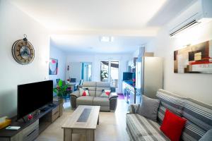 sala de estar con sofá y TV en Superbe appartement à 2 pas des Halles, Climatisé, terrasse, garage en Narbonne