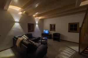 uma sala de estar com um sofá e uma televisão em Holiday Home Planina em Tržič