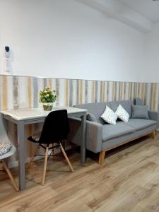 a living room with a couch and a desk at Ángeles home in El Vendrell