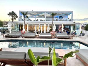 a swimming pool with lounge chairs and a building at MI CAPRICHO 9B BEACHFRONT- Apartment with sea view - Costa del Sol in Mijas Costa