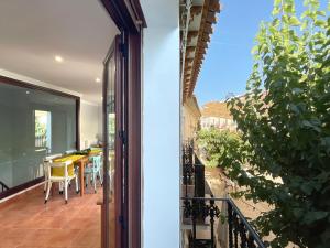 Otwarte drzwi na balkon ze stołem i krzesłami w obiekcie Casa de la Plaza w mieście Fondón