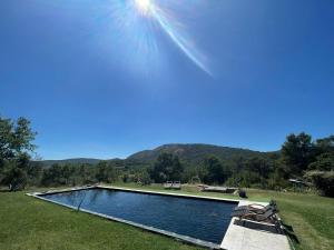 a swimming pool in a field with mountains in the background at 1832 La Rabassière in Malaucène