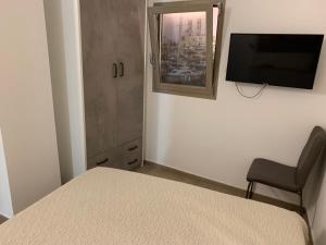 a bedroom with a bed and a chair and a television at Sette Torri 2 in Molfetta
