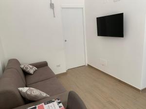 a living room with a couch and a flat screen tv at Sette Torri 2 in Molfetta +2 photos