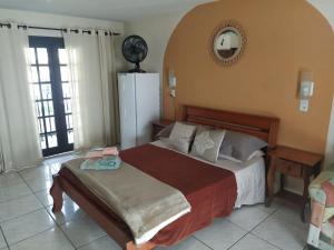 サン・フランシスコ・ド・スルにあるPousada Praia do Calixtoのベッドルーム1室(ベッド1台、壁掛け時計付)