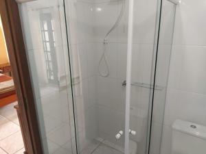 a shower with a glass door in a bathroom at Pousada Praia do Calixto in São Francisco do Sul
