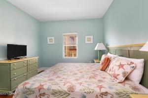 a bedroom with a bed with a dresser and a television at Spacious, cozy 2brd /2bath condo - LakeTown Wharf in Panama City Beach