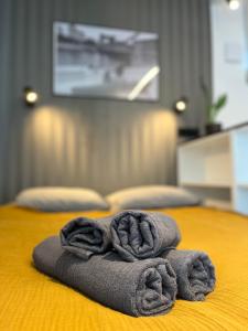 a pile of towels sitting on top of a bed at Halo Apartments in Wrocław