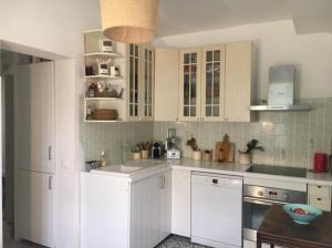 a kitchen with white cabinets and white appliances at Maison de charme en bord de Mer in Le Barcarès