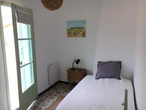 a bedroom with a bed and a window at Maison de charme en bord de Mer in Le Barcarès