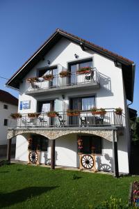 a white building with balconies and flowers on it at House Marinic in Grabovac