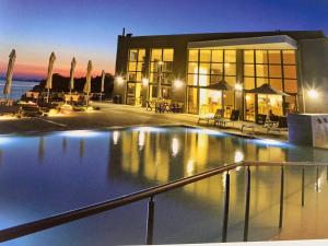 a building with a swimming pool in front of it at Mare - Rooms in Agia Paraskevi