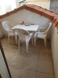 Biały stół i krzesła w pokoju w obiekcie studio pour 3 personnes au calme dans villa w Nicei