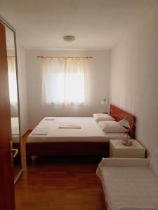 a bedroom with two beds and a window at Apartmani Tamara in Sveti Anton
