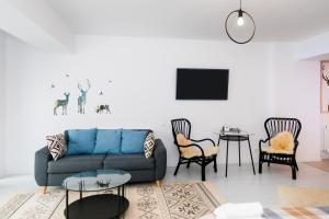 un soggiorno con divano blu e sedie di Anastasia Studio a Predeal