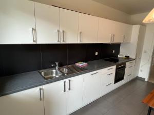 a kitchen with white cabinets and a sink at rooms train station in Luxembourg