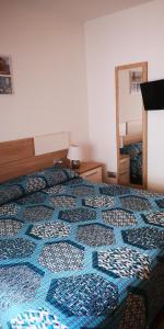 a bedroom with a bed with a blue and white quilt at CABO GATA SUNNY HOUSE in Retamar
