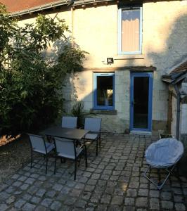 uma mesa e cadeiras em frente a uma casa em Logis de charme en Touraine em Sainte-Maure-de-Touraine