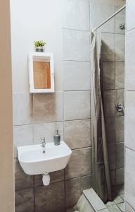 uma casa de banho com um lavatório e um chuveiro em Ambiente Budget Accommodation em Upington